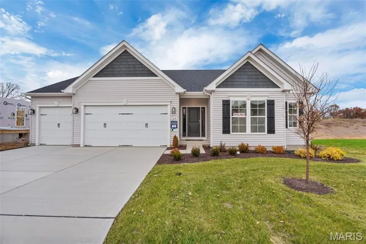 Ranch-style home with a garage, concrete driveway, and a front yard