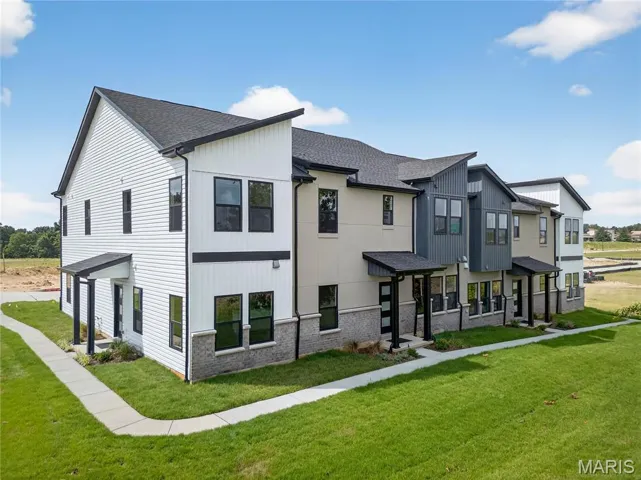 View of front of home featuring a shingled roof, a front lawn, and brick siding