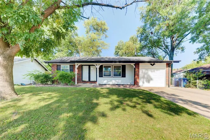 Single story home with an attached garage, driveway, brick siding, and a porch