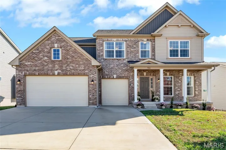 View of front of house featuring driveway, a porch, a front lawn, and brick siding