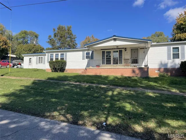 Manufactured / mobile home featuring a porch, a front lawn, and crawl space