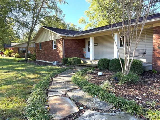View of front of property with brick siding and a front yard