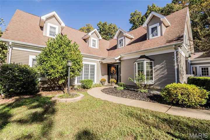New england style home with a front lawn and a shingled roof