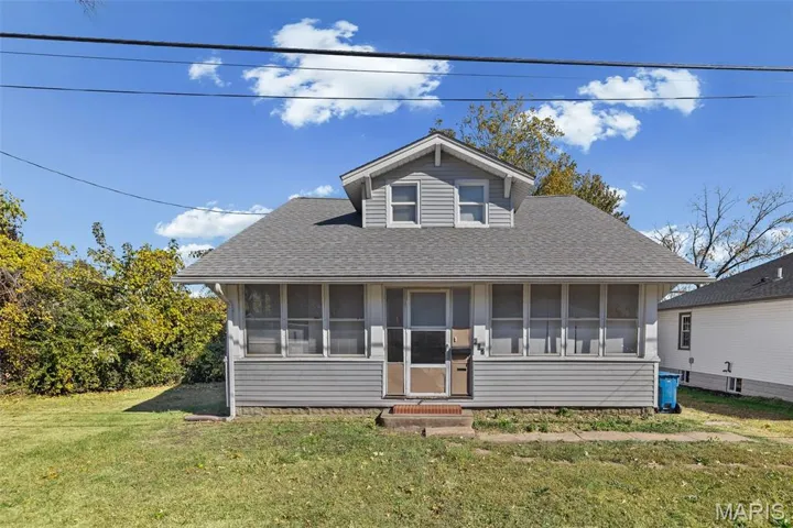 Bungalow with roof with shingles, a front lawn, and a sunroom