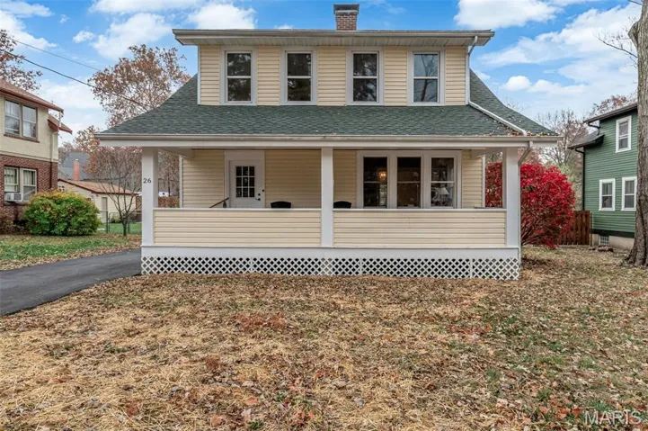 View of front of home featuring a porch, a chimney, and a shingled roof