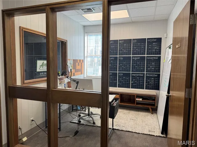 Office area featuring wood walls