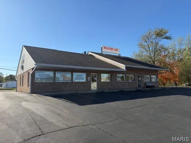 View of property featuring uncovered parking