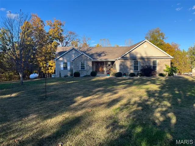 Ranch-style home with a porch, a front lawn, and brick siding