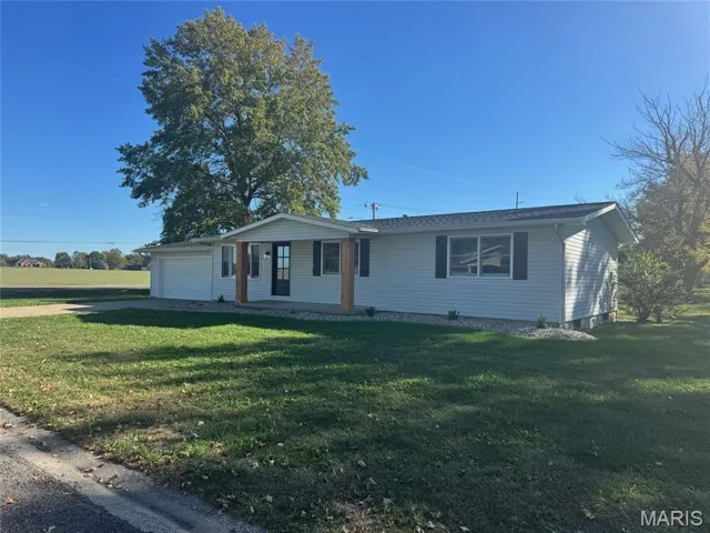 Single story home with a front yard, covered porch, and a garage