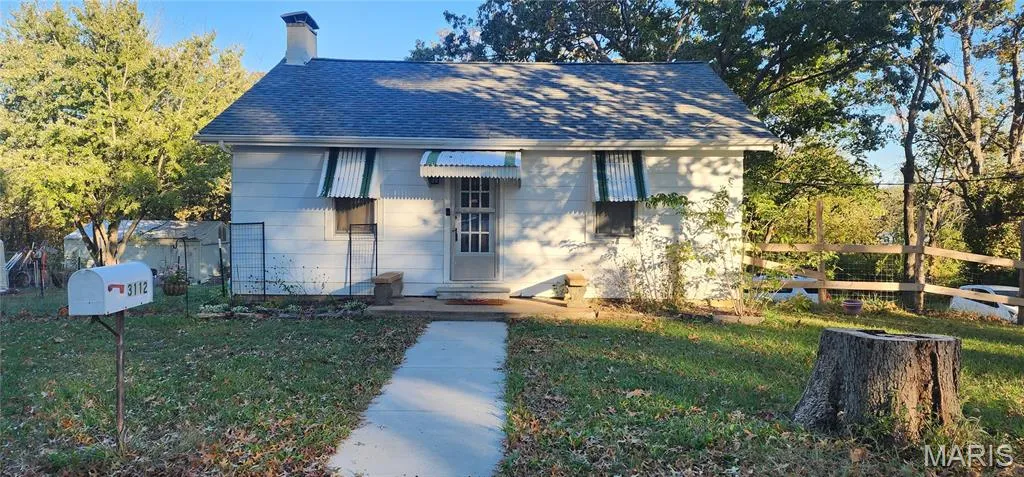 View of front of property with a chimney and a shingled roof