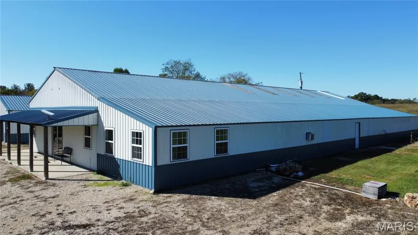 View of side of home with a metal roof and a patio area