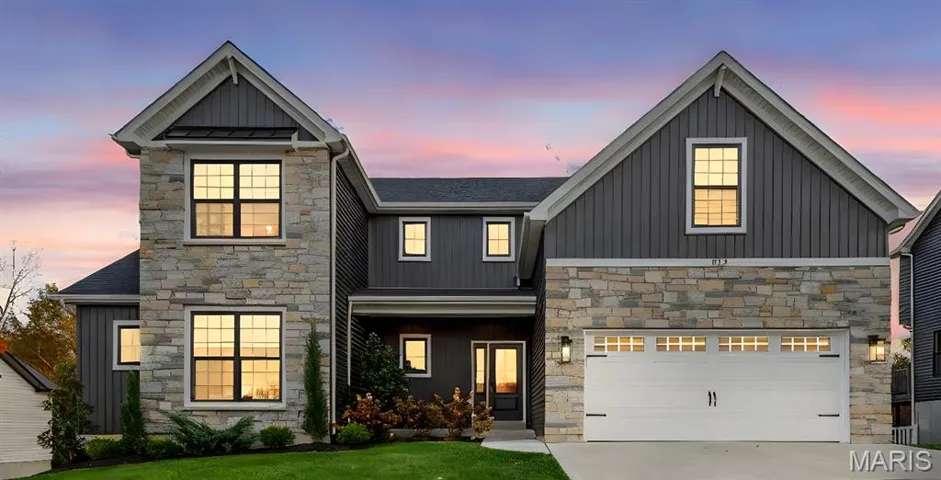 Stone and vinyl facade with black framed windows