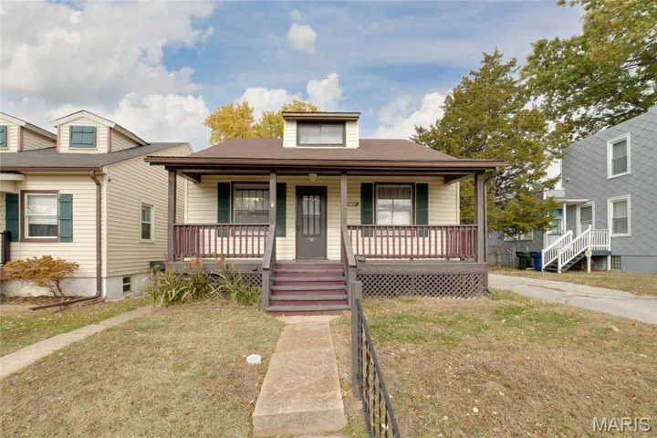 Bungalow-style home with a front yard and covered porch