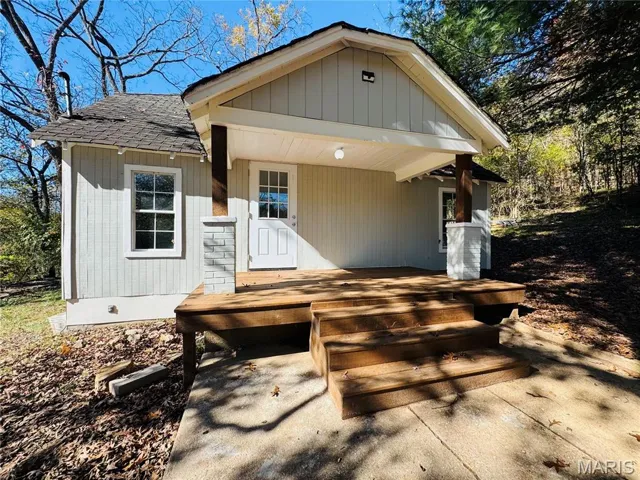 View of front of property featuring roof with shingles and a porch
