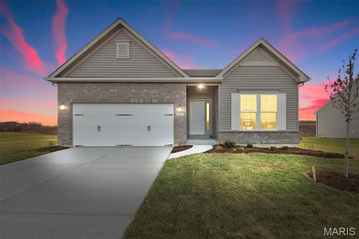 Ranch-style house featuring brick siding, concrete driveway, and a front yard