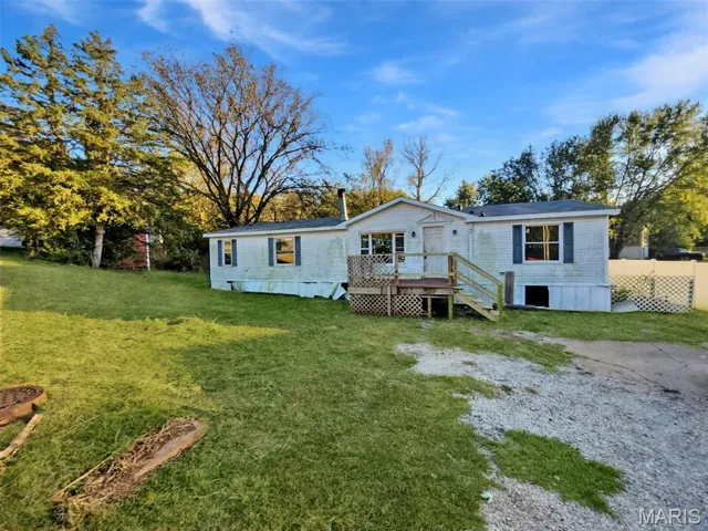 Back of property with a yard and a deck
