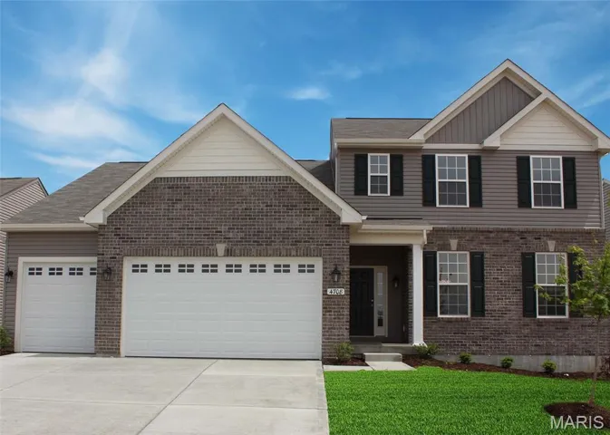 View of front of house with driveway, an attached garage, brick siding, a front lawn, and board and batten siding
