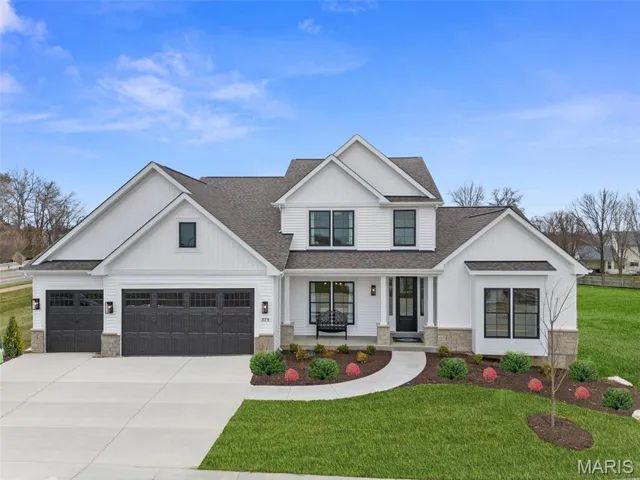 Modern inspired farmhouse featuring a shingled roof, a porch, stone siding, and concrete driveway