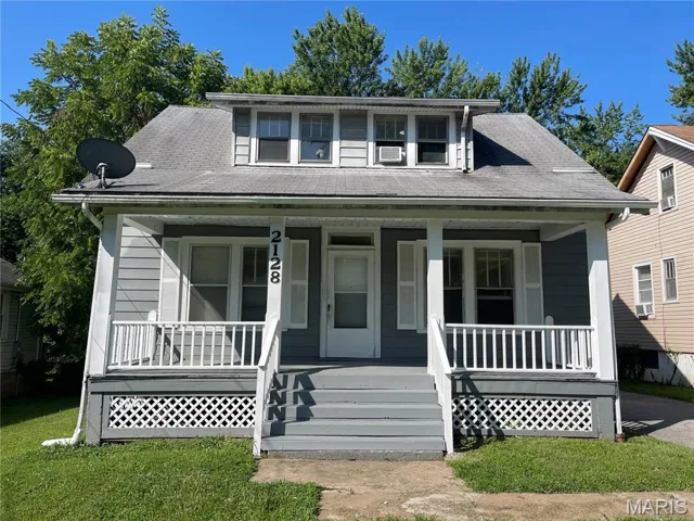 Bungalow-style house with a porch, roof with shingles, and a front yard