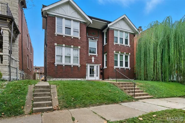 View of front facade with a front lawn and brick siding