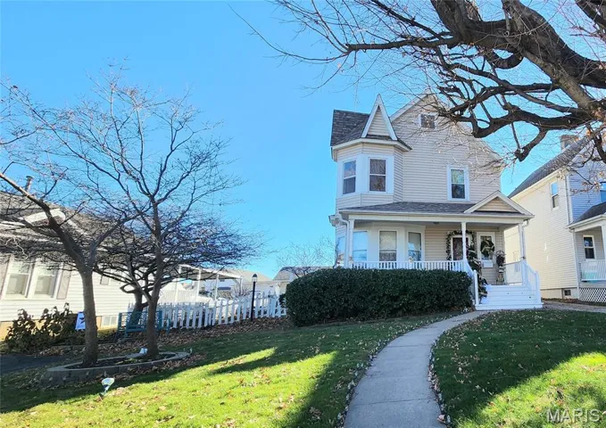 View of property exterior with covered porch and a shingled roof