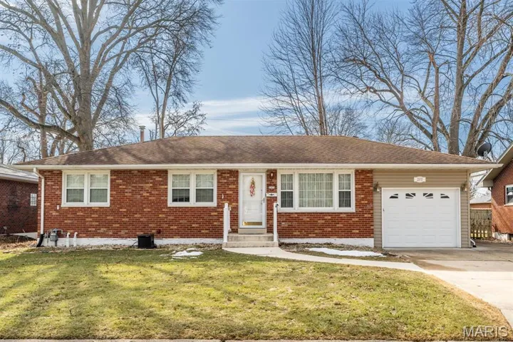 Ranch-style home with a garage, concrete driveway, brick siding, and a front yard