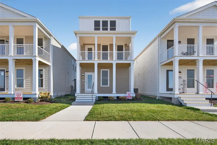 Greek revival house featuring covered porch and a front lawn