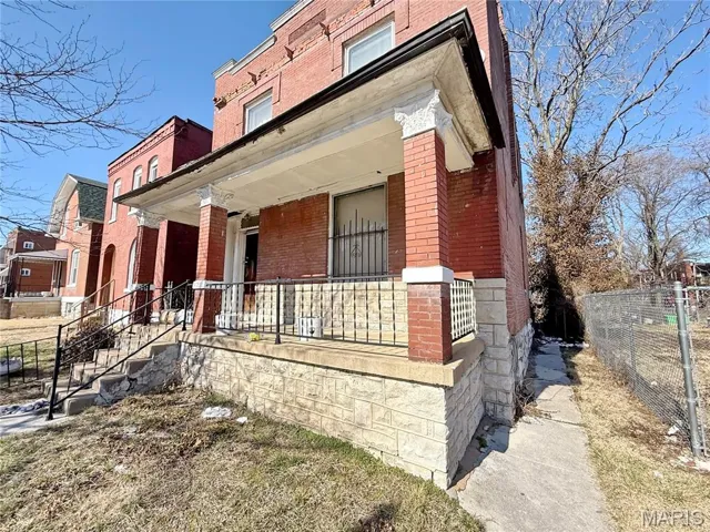 View of side of property featuring brick siding and covered porch