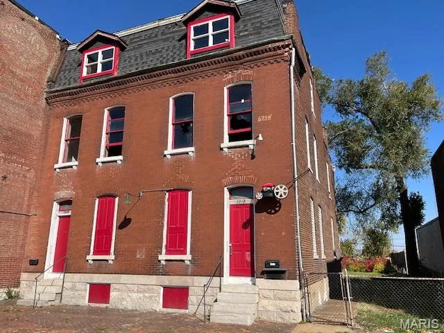 Victorian home with roof with shingles, a gate, mansard roof, and brick siding