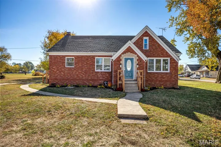 View of front of house featuring a front yard, brick siding, and a shingled roof