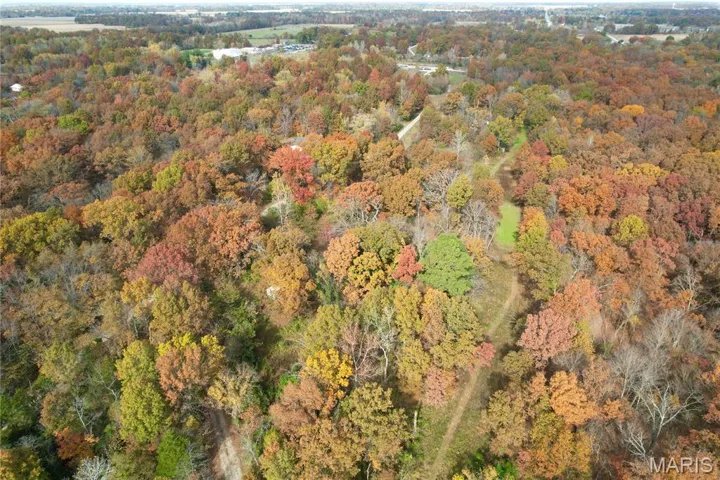 Aerial view of property's location featuring a heavily wooded area