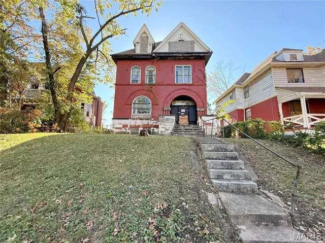 View of front of house featuring brick siding and a front lawn