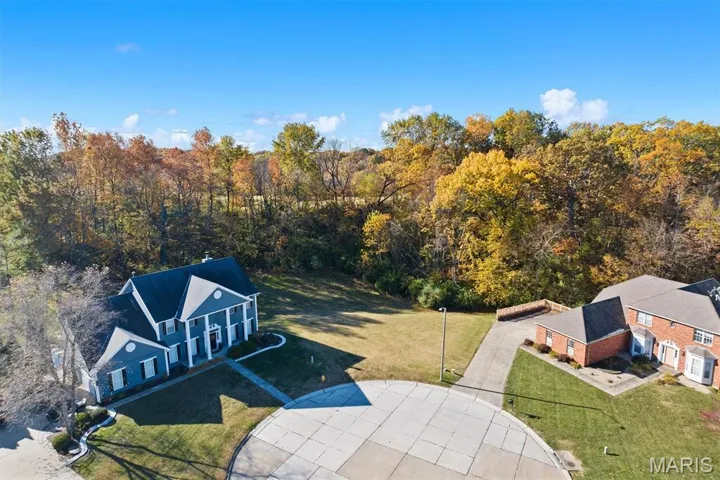 Aerial view of property and surrounding area featuring a forest