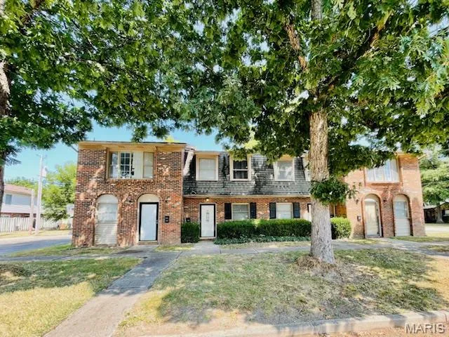 View of front facade with brick siding and a front lawn