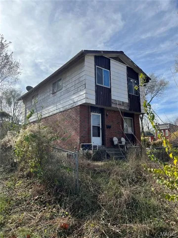 View of property exterior featuring brick siding and a balcony