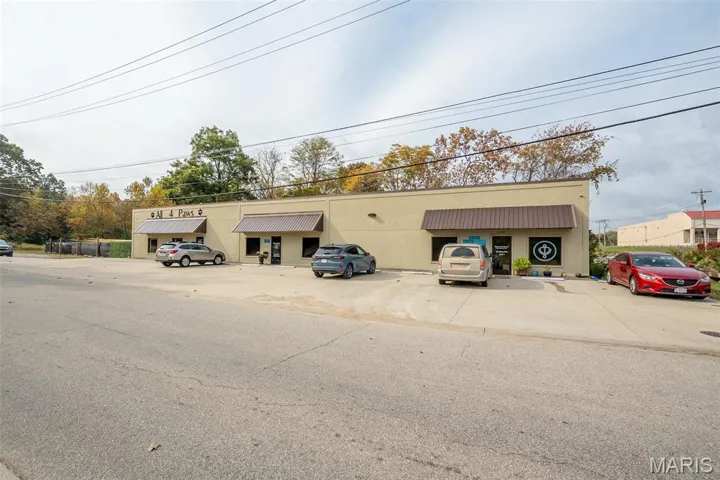 View of property featuring uncovered parking