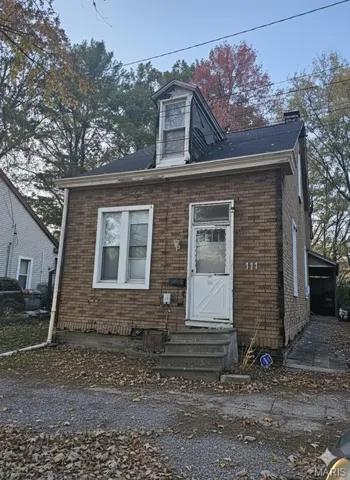 View of front of house featuring entry steps, brick siding, and a chimney