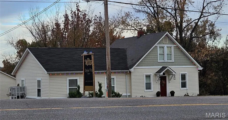 View of front of home with a shingled roof and a chimney