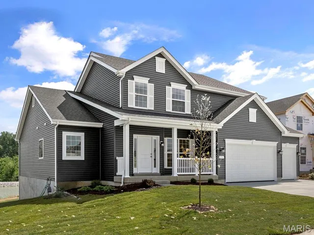 Traditional home with covered porch, a front lawn, and a shingled roof