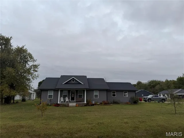 View of front facade with a porch and a front lawn
