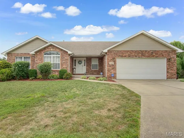 Single story home featuring covered porch, a front lawn, driveway, a garage, and roof with shingles