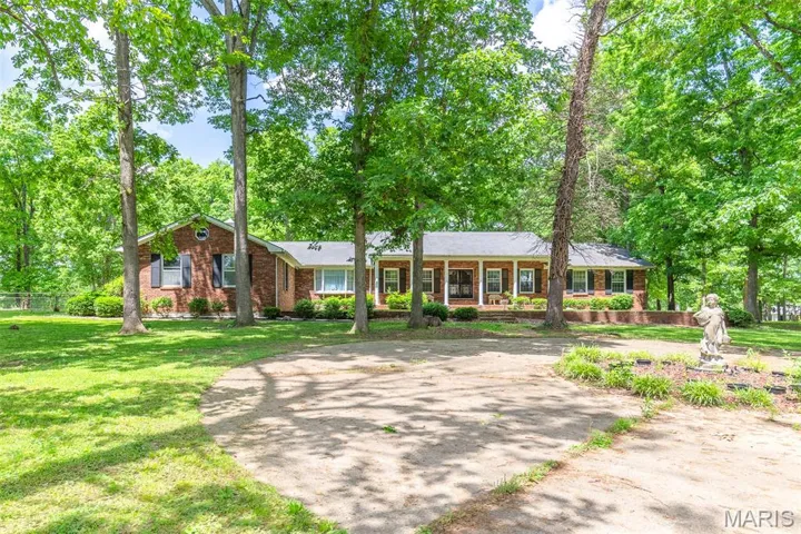 Single story home featuring brick siding and a front yard