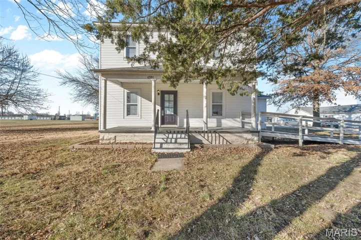 Rear view of property with a yard and covered porch