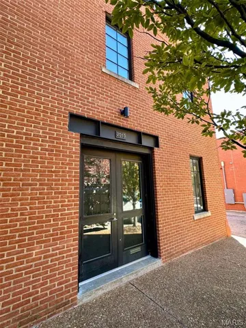 View of exterior entry with brick siding and french doors