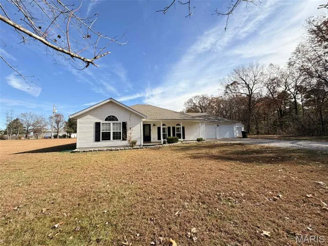 Ranch-style house featuring a front lawn and driveway