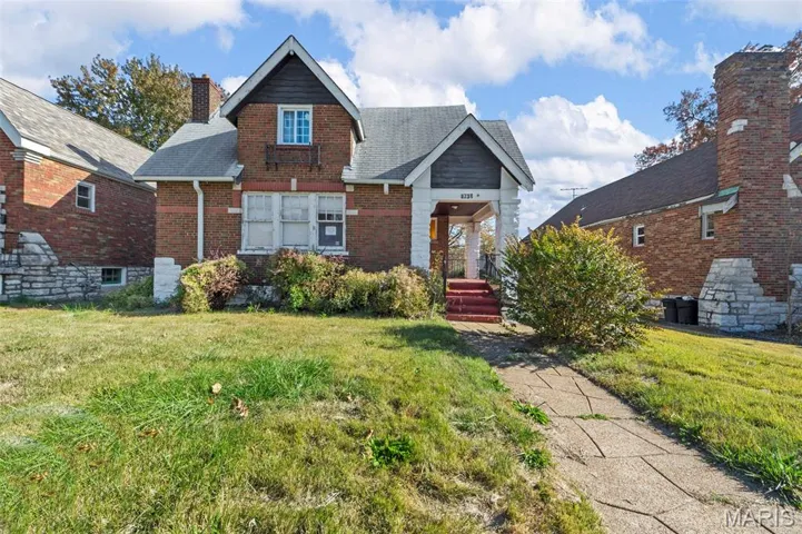 View of front of property featuring brick siding, a front yard, and roof with shingles