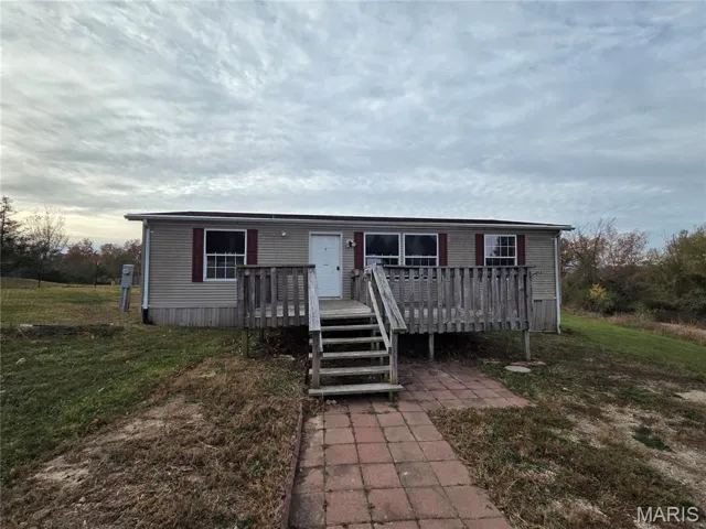 Manufactured / mobile home featuring a front yard and a deck