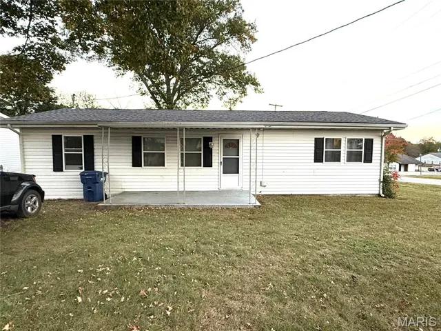 View of front facade with a front yard and a shingled roof