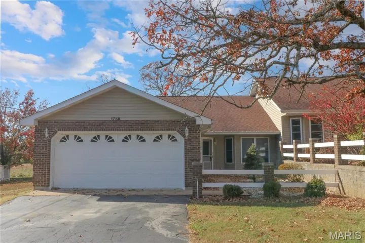 View of front of property featuring brick siding, driveway, a garage, and a shingled roof