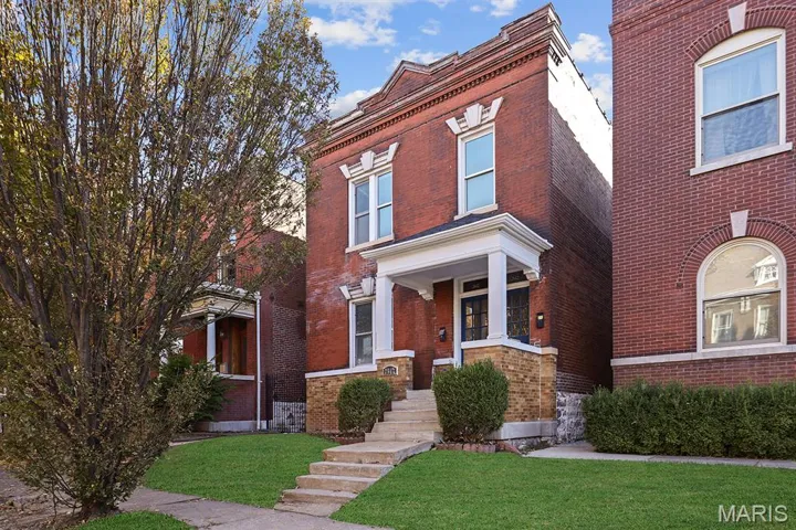 View of front of home with brick siding and a front yard